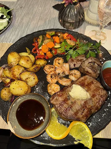 Steak mit Garnelen und gegrilltem Gemüse auf einem Teller